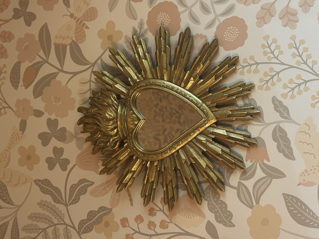 Miroir soleil sur papier peint fleuri